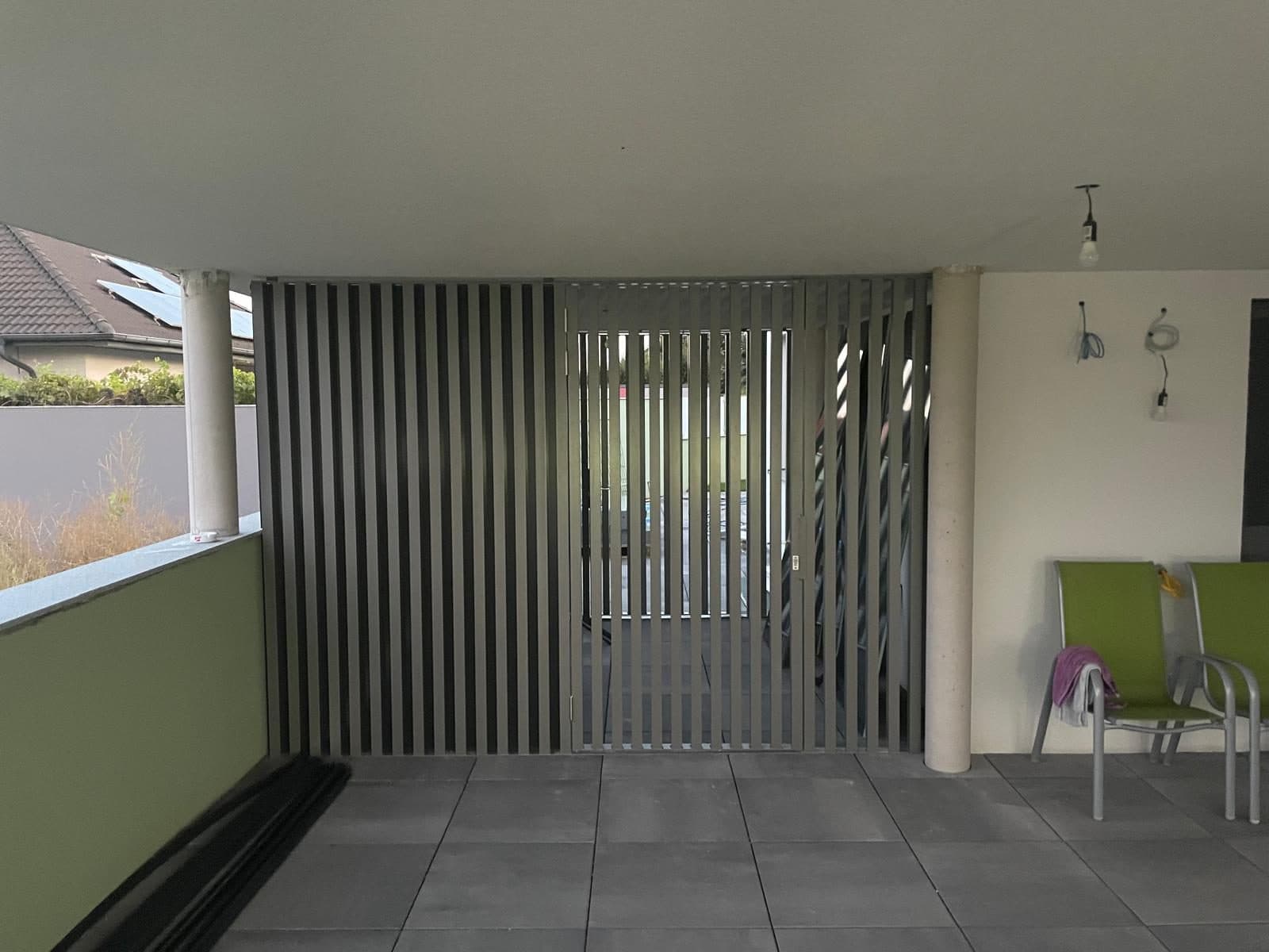 Vertikale Lamellenwand als Sichtschutz in einer überdachten Loggia