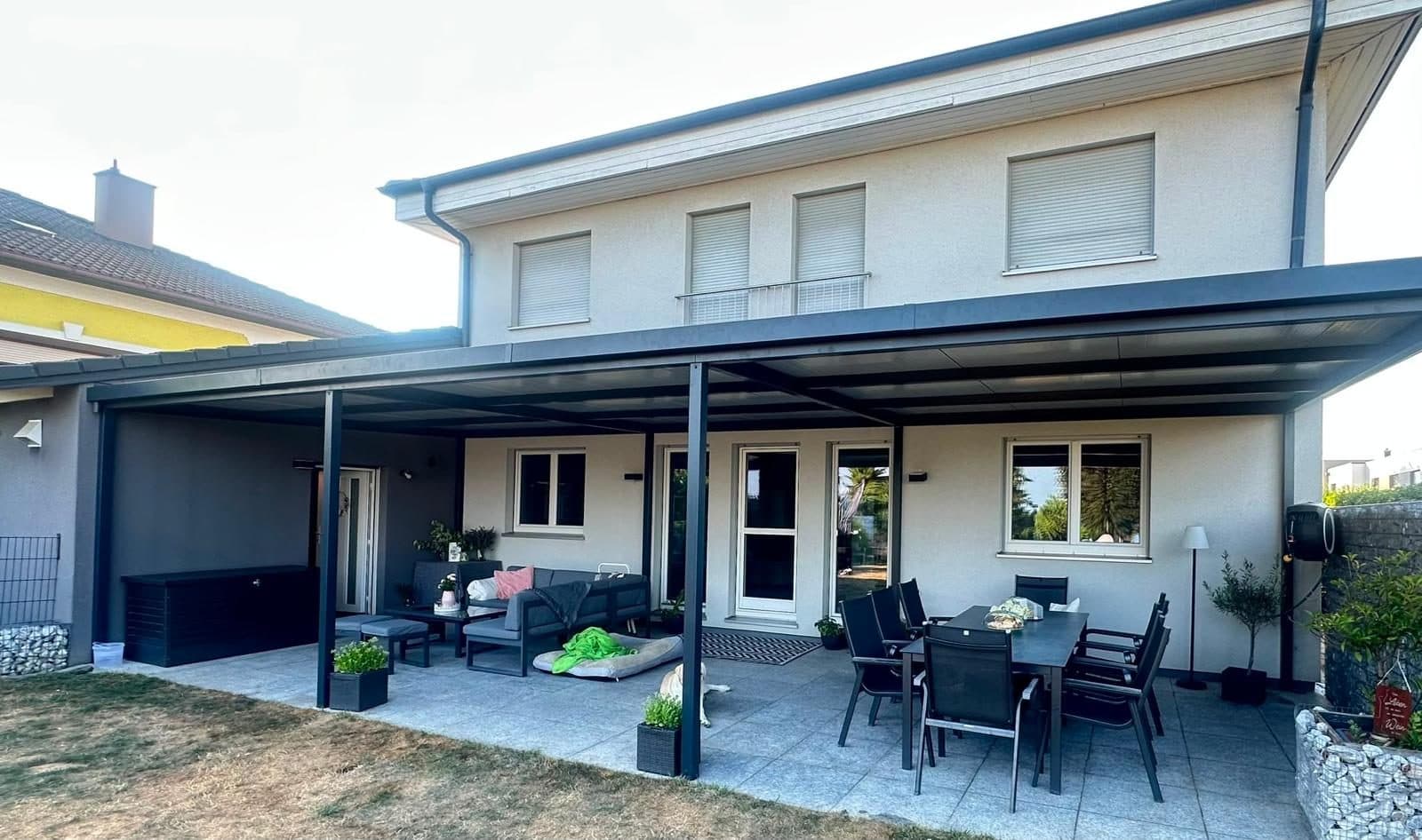 Lange Terrassenüberdachung über die gesamte Hausbreite mit Essplatz