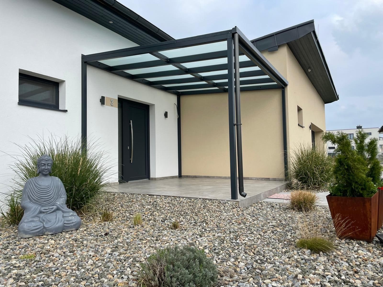 Vordach mit Glaseindeckung über dem Hauseingang eines Bungalows