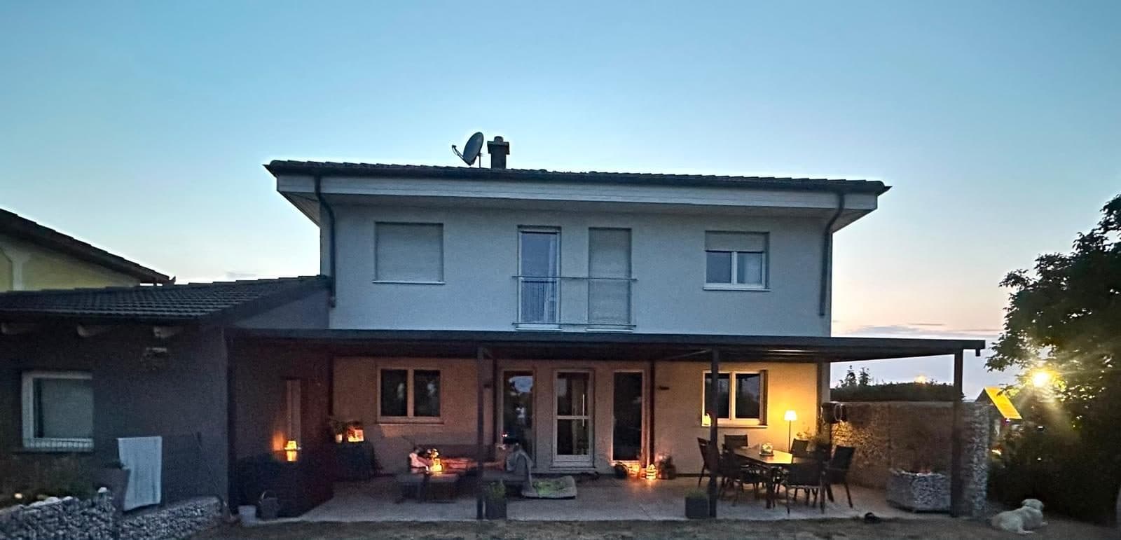 Terrassenüberdachung von AM Outdoor Solutions in der Abenddämmerung